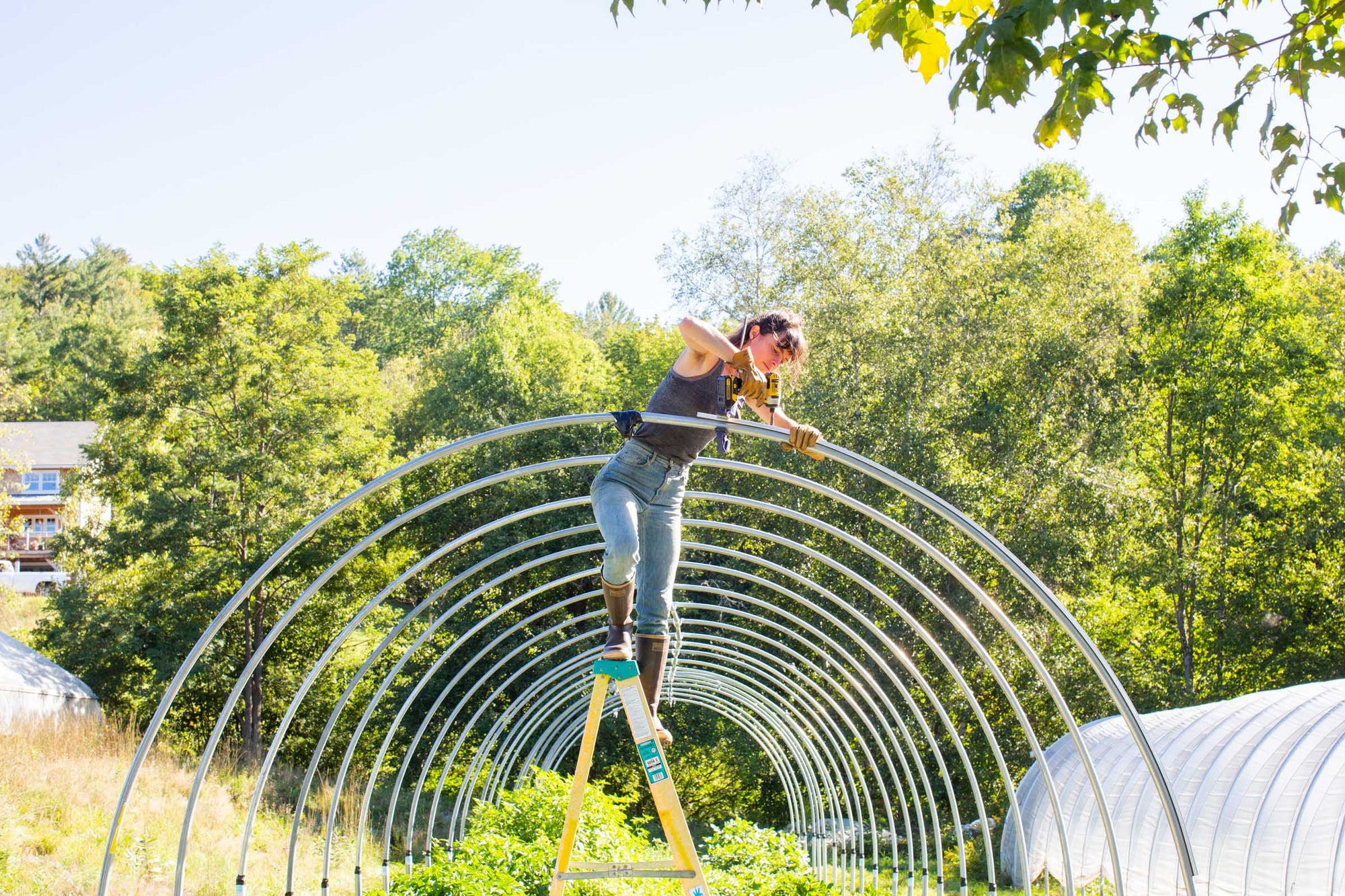 A woman wearing Vermont Glove while working on a greenhouse